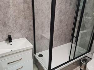 a shower with a glass door next to a sink at 4 New Assembly Close - Royal Mile in Edinburgh