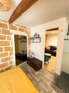 a living room with a brick wall at Le Chapeau Rouge - Centre Historique - Corum in Montpellier