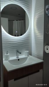 ein Bad mit einem Waschbecken und einem Spiegel in der Unterkunft Iva Lux apartman in Zaječar