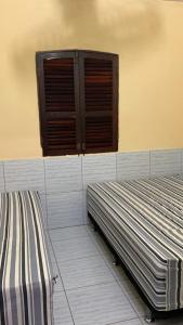 two beds sitting next to each other in a room at Casa Temporada Lucena -PB in Lucena