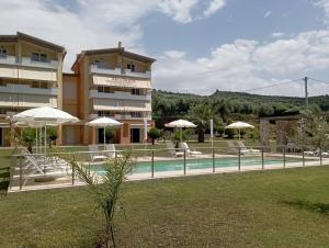 a hotel with a pool and umbrellas next to a building at Alex House in Zacharo