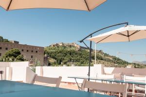 a table and chairs with an umbrella and a mountain at La casa alta in Sagunto