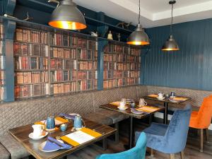 a dining room with two tables and books at Grianaig Guest House & Restaurant, South Uist, Outer Hebrides in Daliburgh