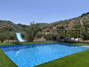 een zwembad met een glijbaan en een speeltuin bij Alojamiento Rural Cortijo Alameda, Las Lagunillas in Priego de Córdoba