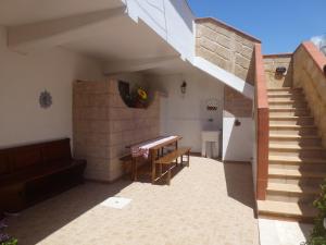 a patio with a table and stairs in a house at La vedetta in San Pietro in Bevagna