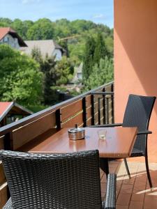 uma mesa de madeira e cadeiras numa varanda em Hotel Restaurant Toscana em Bad Orb