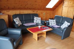 a living room with couches and a coffee table at Haus Seerobbe-Obergeschosswohnung in Fehmarn