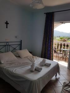 a bedroom with a white bed with towels on it at Villasabella in Laganas +133 photos