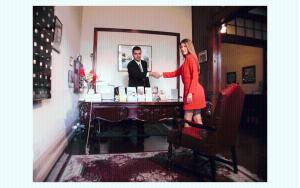 a woman is standing at a table in front of a mirror at Hotel Santo Tomás in San José