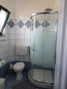 a bathroom with a toilet and a glass shower at Villasabella in Laganas