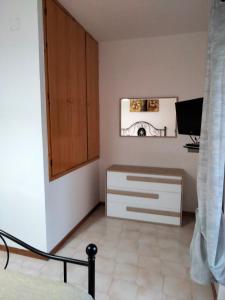 - une chambre avec un lit et une commode dans l'établissement Villetta Clorinda, à San Nicola Arcella