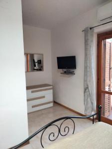 1 dormitorio con 1 cama y TV en la pared en Villetta Clorinda, en San Nicola Arcella