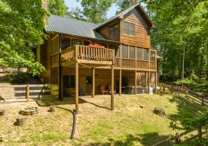 a log house with a porch and a deck at Spacious cabin with resort amenities - dog friendly, hot tub, & fireplace - Bear Paw Ridge in Ellijay