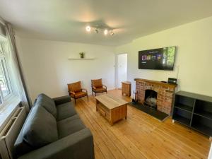 a living room with a couch and a fireplace at Cheerful 2-bedroom bungalow with free parking in Newton Poppleford