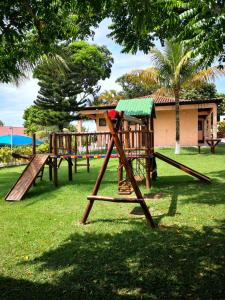 a playground with two wooden swings in a park at Flat Gorlaes in Araruama