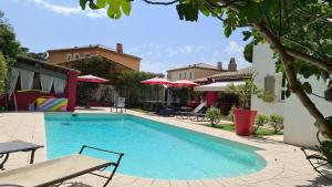 a swimming pool with a bench and tables and umbrellas at Ste Maxime Villa 5 etoiles Piscine chauffée et jacuzzi in Sainte-Maxime