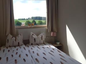 uma cama com almofadas num quarto com uma janela em Domein Hellebeuk met UITZICHT! Valkenburg/Klimmen em Klimmen