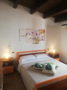 ein Schlafzimmer mit einem Bett mit zwei Lampen und zwei Gemälden an der Wand in der Unterkunft By the Sea Apartment #4 in Terrasini