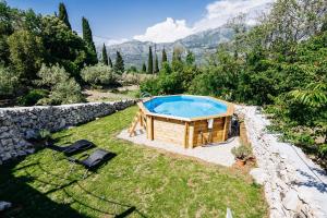 a pool in a yard next to a stone wall at Green Hill Apartment in Komaji