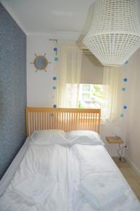 Magic Marine Apartment في دجيفنوفيك: سرير أبيض في غرفة نوم مع نافذة