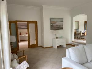un soggiorno con un divano bianco e un tavolo di Soltroia Glamorous Villa a Tróia Altre 56 foto