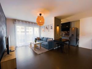 - un salon avec un canapé bleu et une table dans l'établissement Le Monseigneur's House - Duplex hyper centre, à Courcouronnes