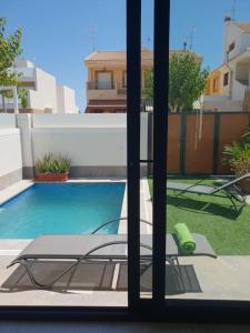 Una vista de una piscina desde una ventana. en Espanhouse Villa in Pilar de la Horadada, en Pilar de la Horadada