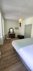 1 dormitorio con 1 cama, 1 silla y 1 mesa en Le Gîte du Nohain en Entrains-sur-Nohain