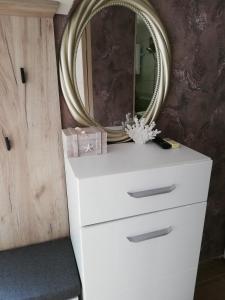 a white dresser with a mirror on top of it at Guest House Ivy in Ravda