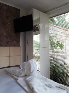 a bedroom with a bed with a television on the wall at Guest House Ivy in Ravda