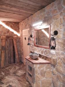 kamienna łazienka z umywalką i lustrem w obiekcie Resort Hanni Deisenberger w mieście Fieberbrunn