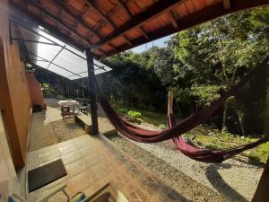 um alpendre com rede numa casa em Casa Kiiro, um ambiente tranquilo e de sossego. em Santo Antônio do Pinhal