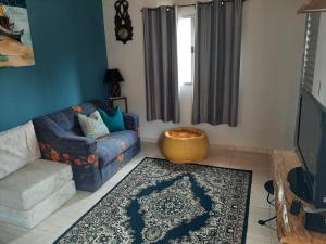 a living room with a couch and a rug at Casa Kiiro, um ambiente tranquilo e de sossego. in Santo Antônio do Pinhal