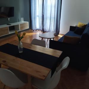 sala de estar con mesa y sofá en Apartament Aksamitny, en Toruń