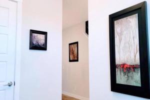 two framed paintings on a wall next to a door at Brand New 3-Bedroom Home in a Quiet Neighborhood in Calgary