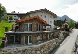 dom na kamiennej ścianie obok drogi w obiekcie Resort Hanni Deisenberger w mieście Fieberbrunn