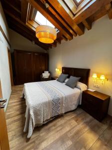 a bedroom with a large bed with a wooden floor at Apartamentos Los Molinos in Llanes
