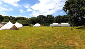 A garden outside Glamping in the Kent weald nr Tenterden Spacious quite site up to 6 equipped tents, each group has their own facilities Tranquil and beautiful rural location yet just an hour to London