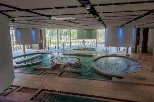 a pool of water with three hot tubs in a building at Second Home Apartments Miskolctapolca in Miskolctapolca