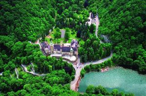 an aerial view of a house on a hill next to a lake at Second Home Apartments Miskolctapolca in Miskolctapolca