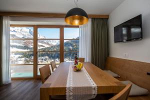 mesa de comedor con vistas a la montaña en Apartments Picenin, en La Villa