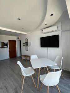 una sala de reuniones con mesa blanca y sillas en Vila Mimoza, en Eforie Nord