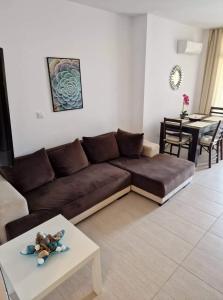 sala de estar con sofá marrón y mesa en Green Life Beach Resort- Апартамент Фемили 2 en Sozopol