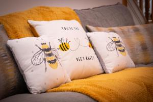 a group of pillows with bees on them on a couch at Ideal Lodgings in Bury - Redvales in Bury