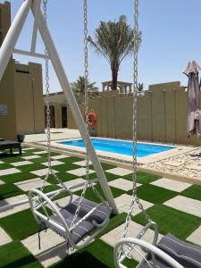 a swing in front of a swimming pool at 2 Bedroom Villa in Ras Al Khaimah with Privat swimming Pool in Ras al Khaimah