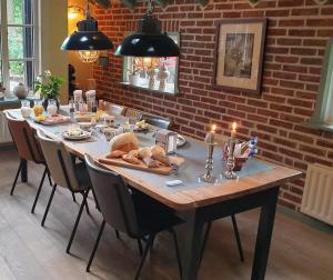 a table with bread and candles on top of it at Bed en Breakfast De Boksloot in Ravenswoud