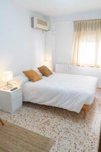 a bedroom with a large white bed and a window at House Los Angeles in Chulilla