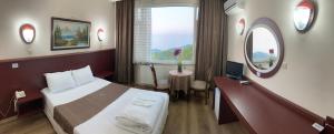 Habitación de hotel con cama, escritorio y espejo. en Zarha Mountain Resort, en Sürmene
