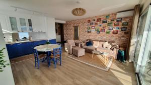 una sala de estar con una pared de ladrillo y una mesa en Blue Eye Apartment, en Sarandë