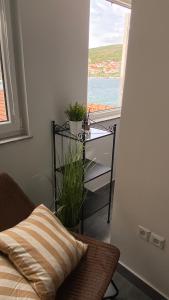 a room with a bed and a table with a window at Apartments Tribunj in Tribunj